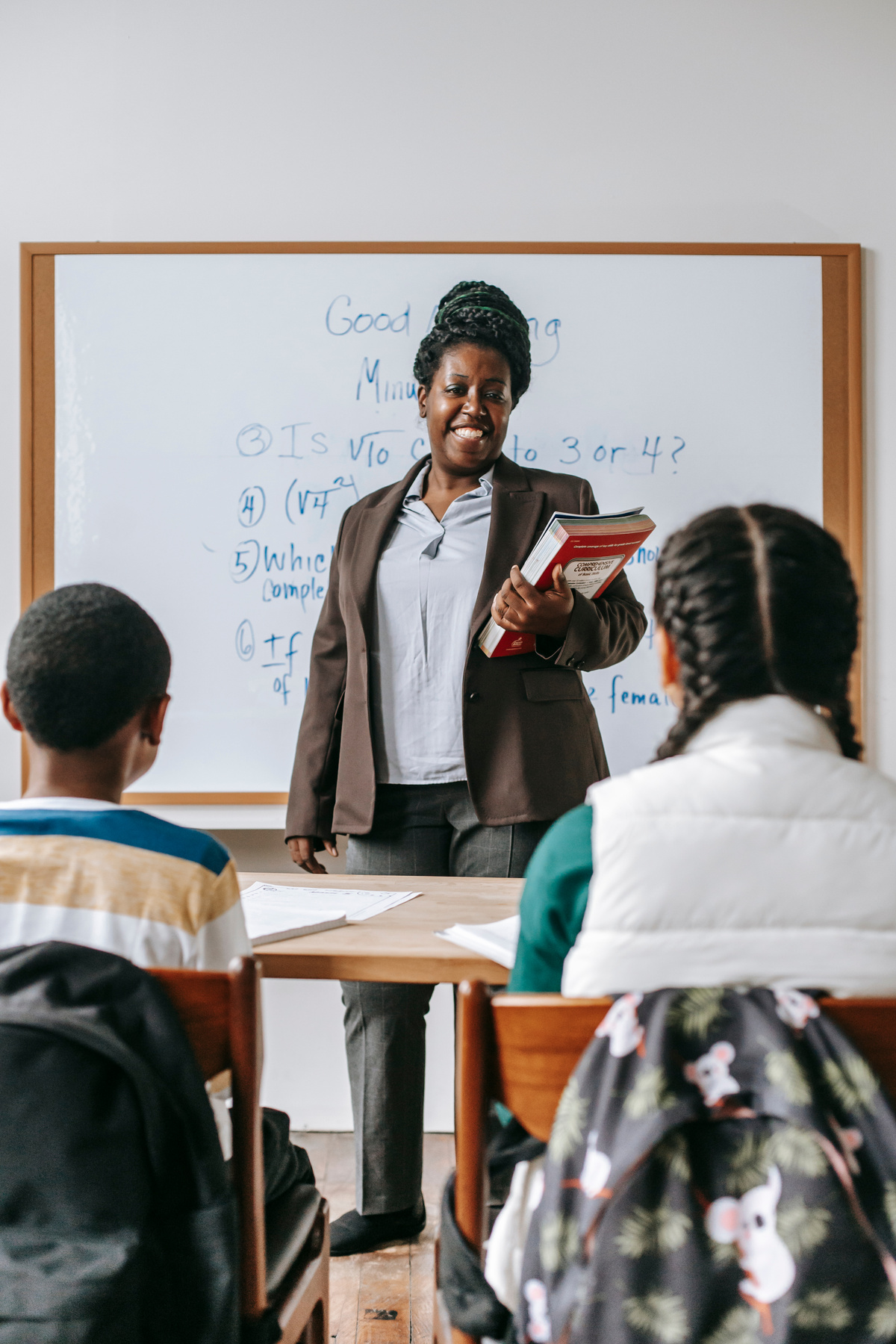 Cheerful black teacher with kids in classroom