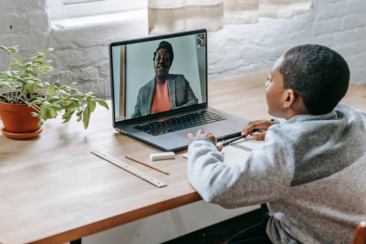 Black boy talking with teacher online